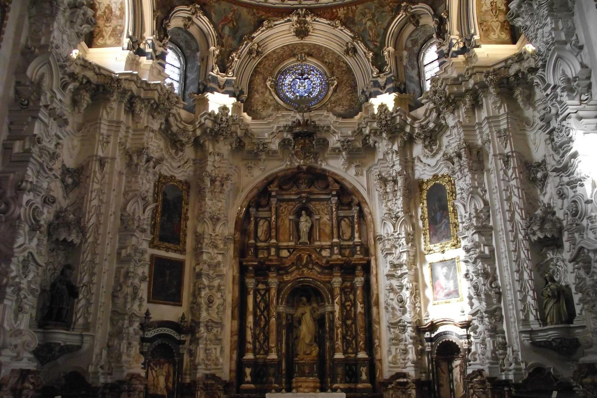 Sacristía de la Cartuja de Granada, con yeserías barrocas blancas y el retablo al fondo