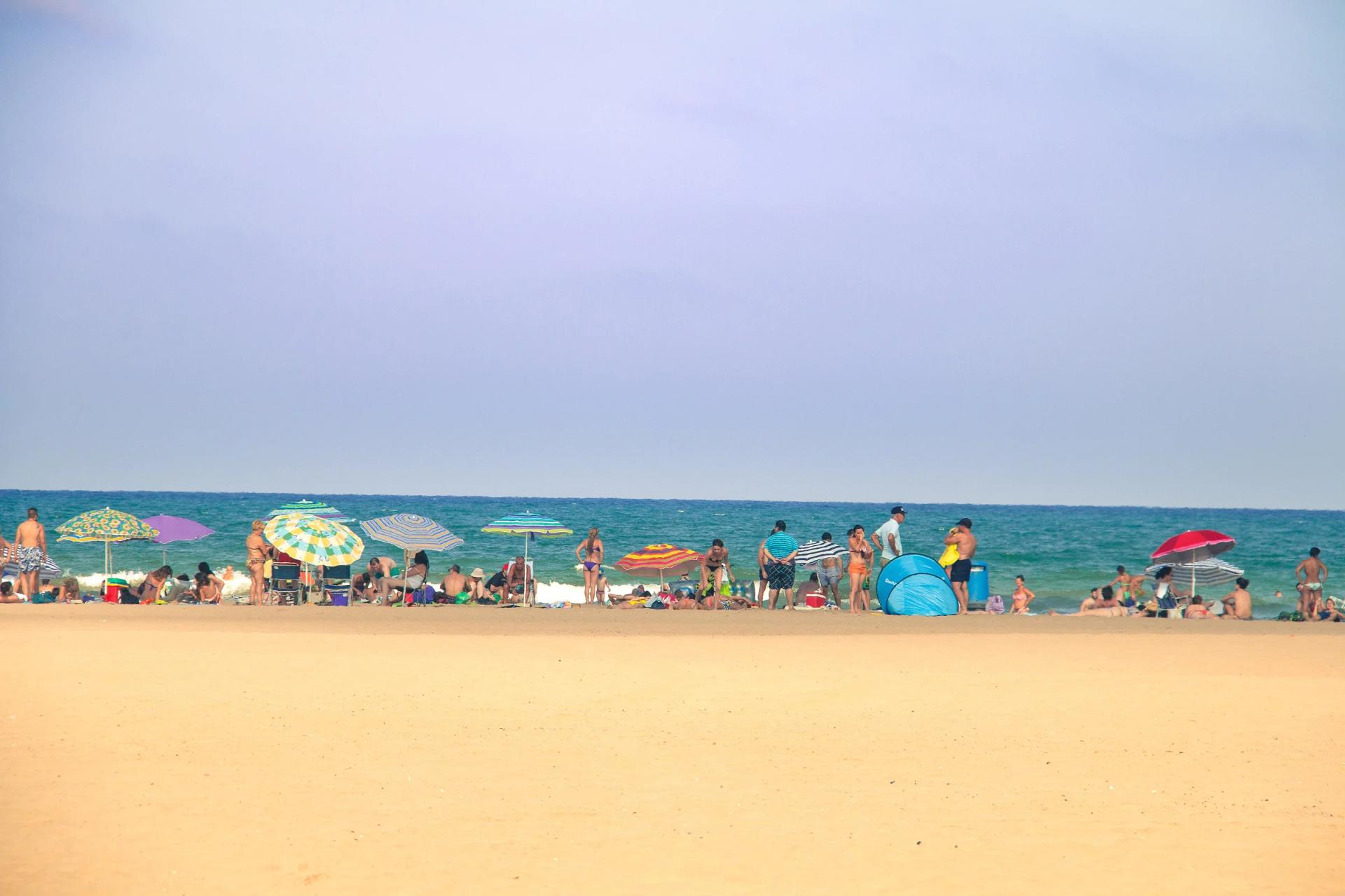 La playa de la Malvarrosa, ancha y de arena fina, con sombrillas junto a la orilla