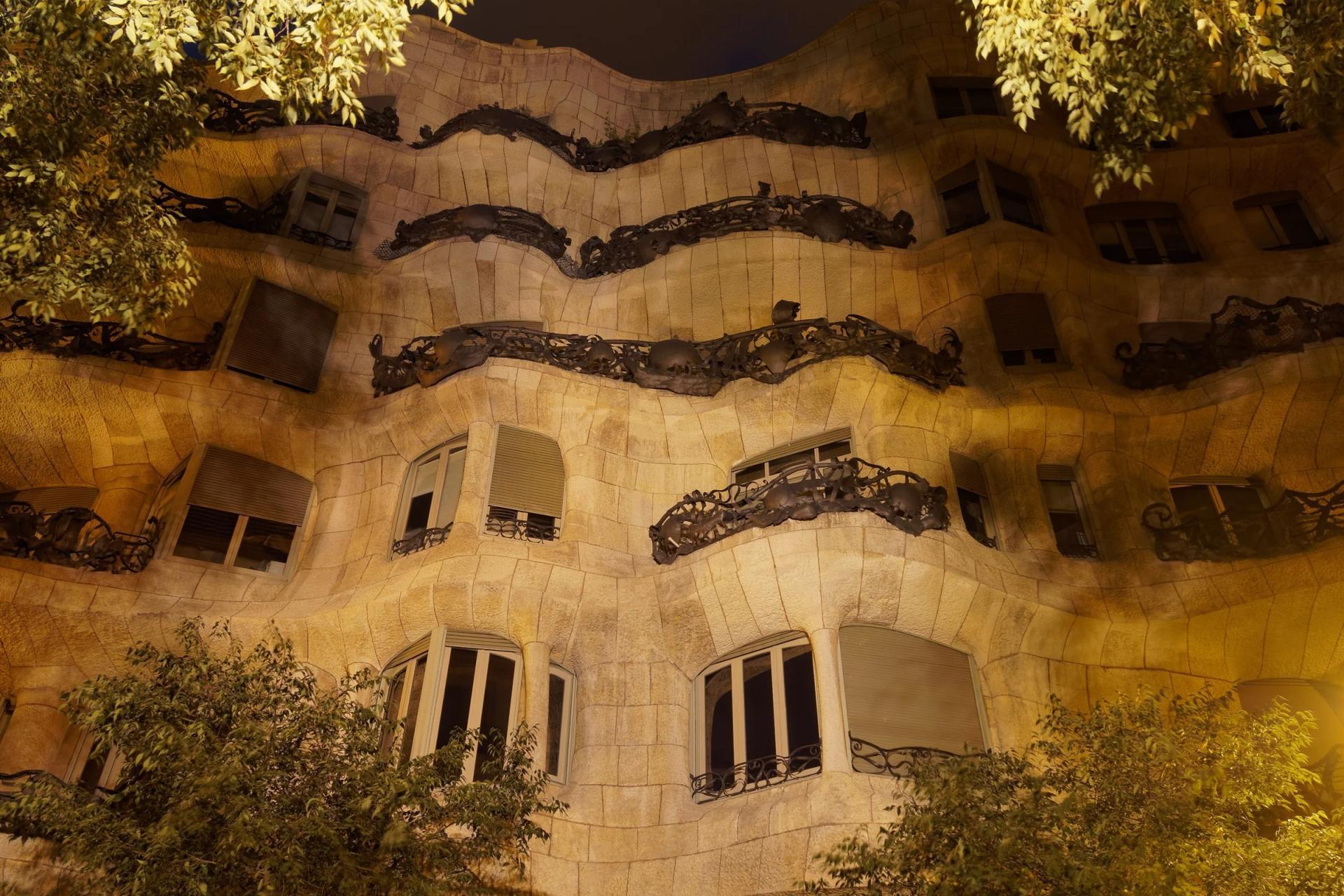 Fachada ondulada de piedra de la Casa Milà (La Pedrera) iluminada al anochecer