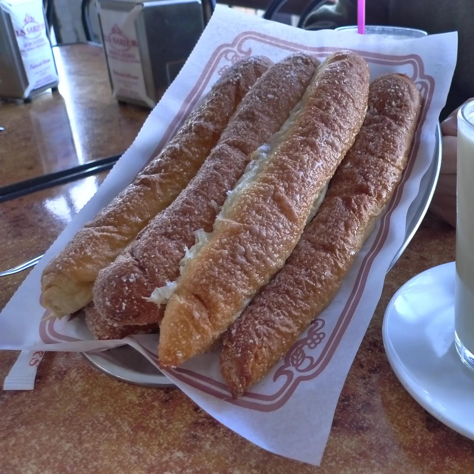 Vaso de horchata fría junto a un plato de fartons