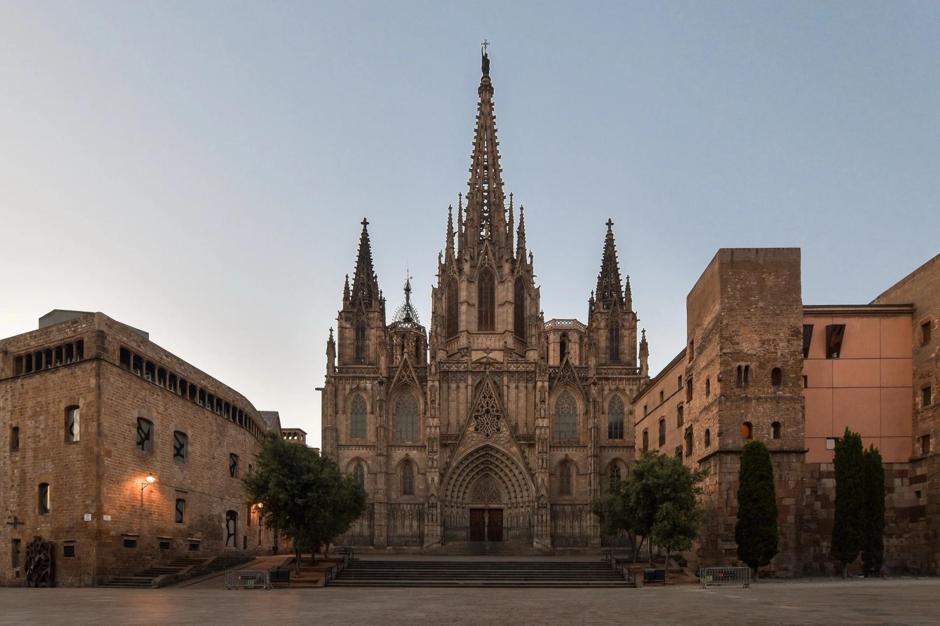 Fachada principal de la catedral de Barcelona al amanecer, con la plaza vacía delante