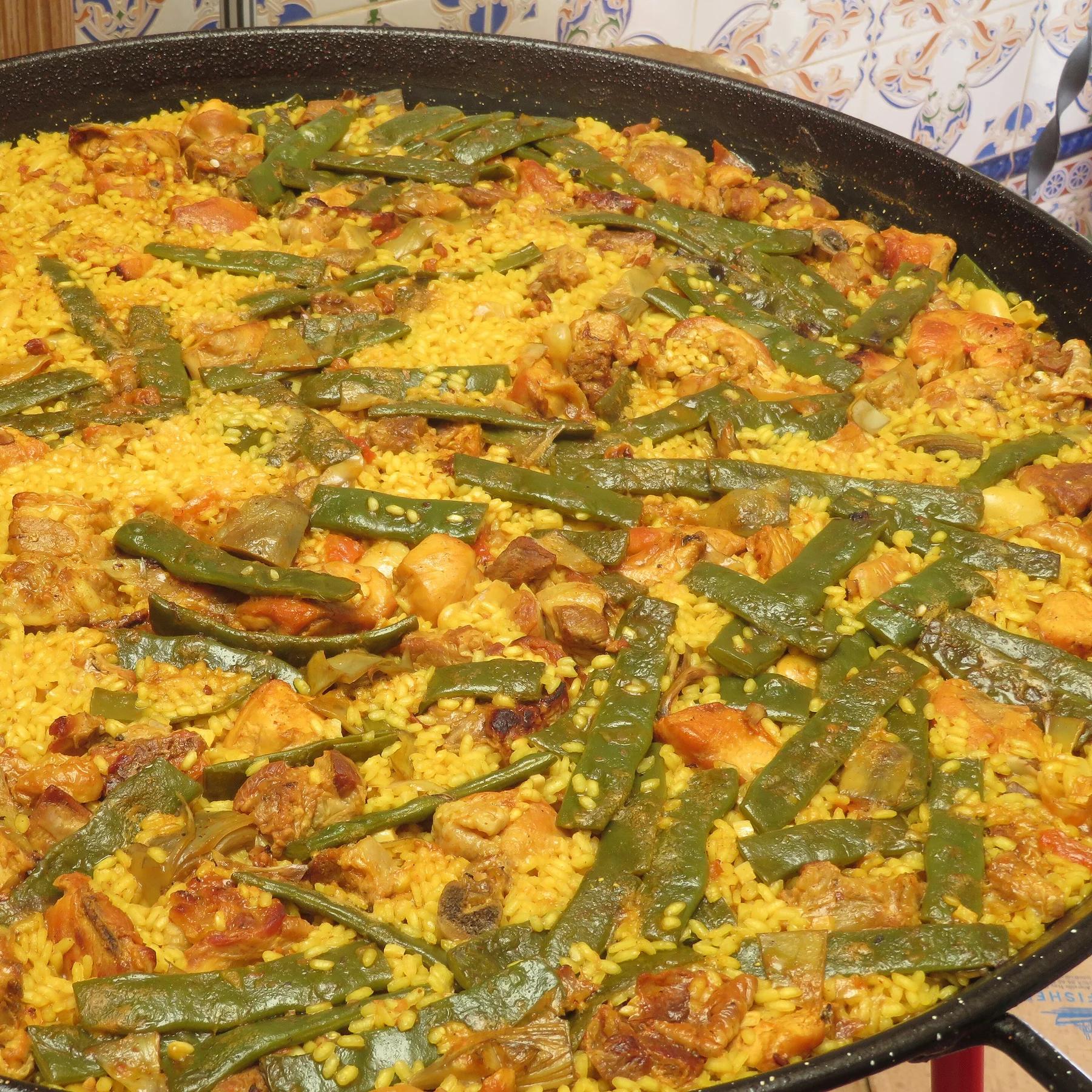 Paella valenciana con pollo y judía verde, terminando de hacer el socarrat en la paellera