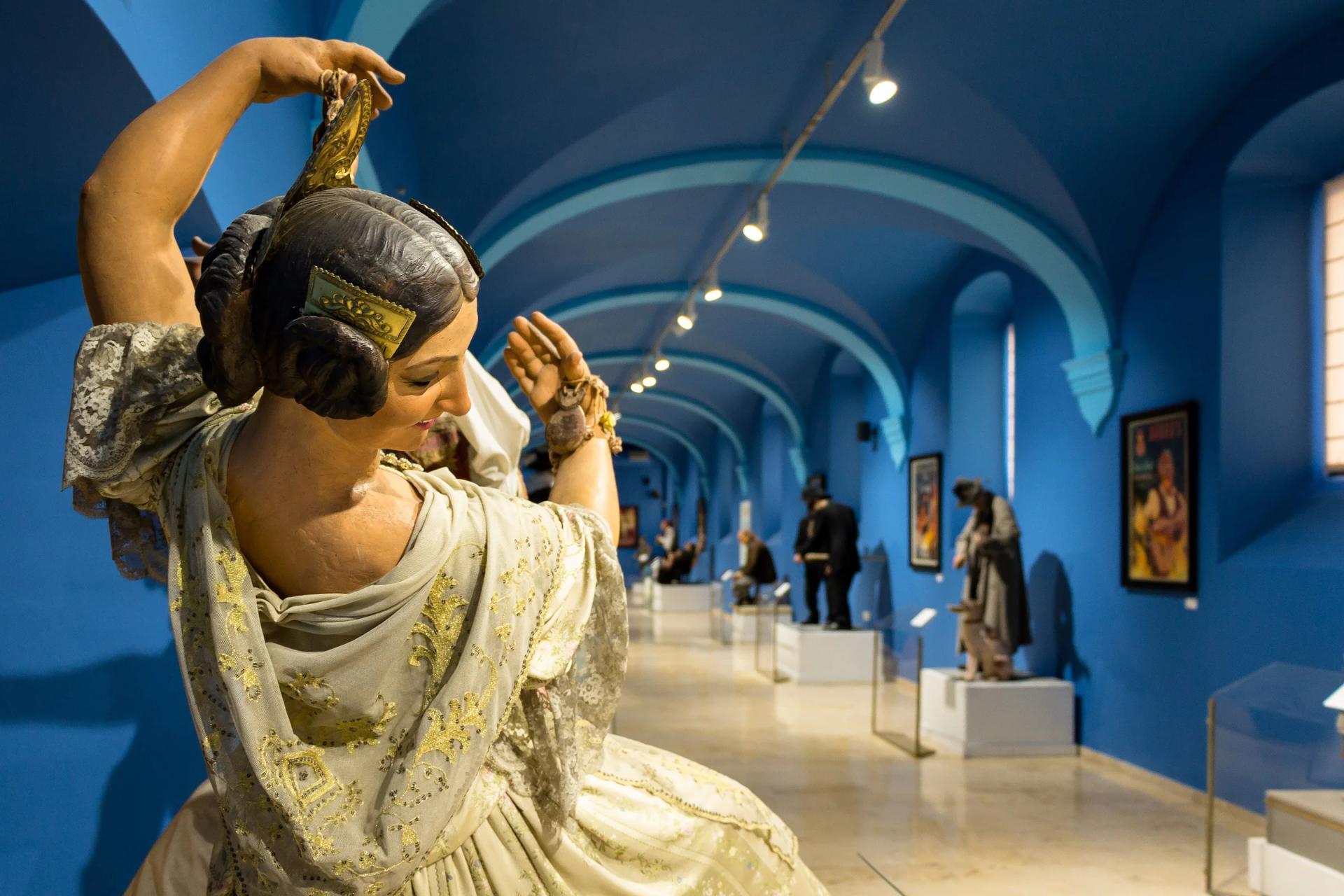 Un ninot indultado en primer plano y, detrás, la galería del Museo Fallero con más figuras y carteles