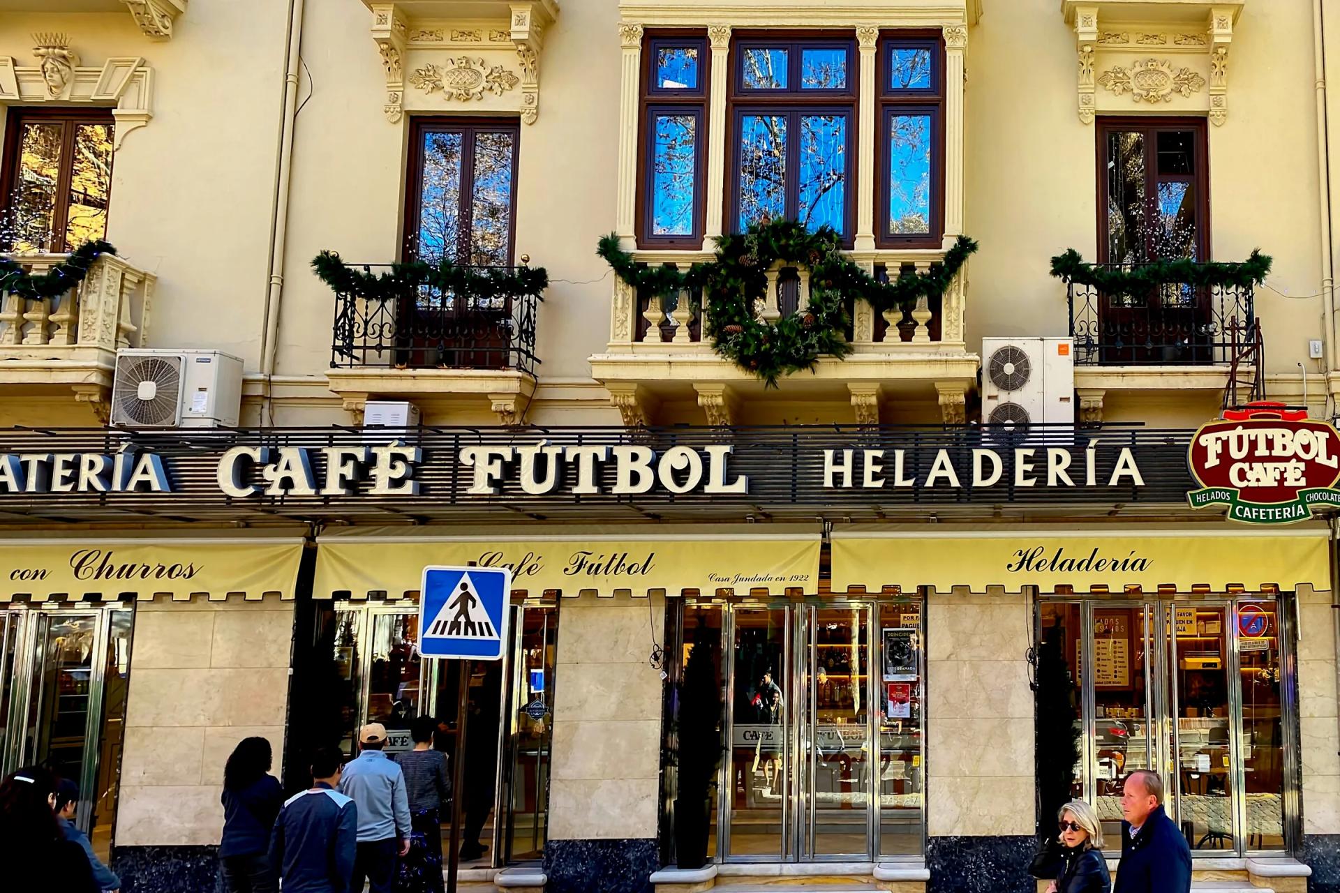 Fachada del Café Fútbol en la plaza de Mariana Pineda, con sus toldos y el rótulo de cafetería y heladería