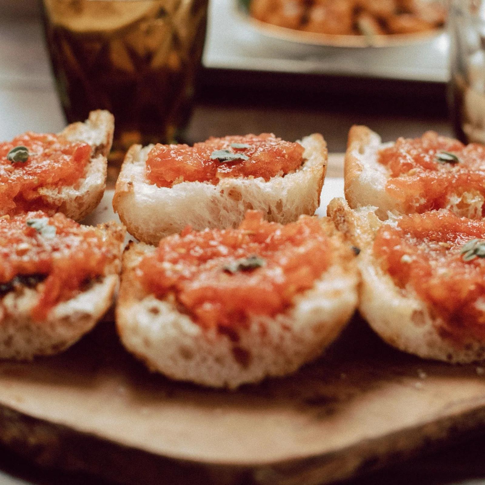 Rebanadas de pan con tomate sobre una tabla de madera